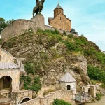 Metekhi Church and the equestrian statue of King Vakhtang Gorgasali on a rocky cliff overlooking the Mtkvari River in Tbilisi