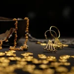 A close-up of intricate ancient gold jewelry and small gold artifacts displayed on a dark surface, part of the valuable collection at the Georgian National Museum in Tbilisi.