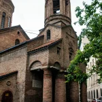 Close-up of an old brick church in Tbilisi Old Town with a distinctive bell tower, arched entrances, and traditional Georgian architecture.