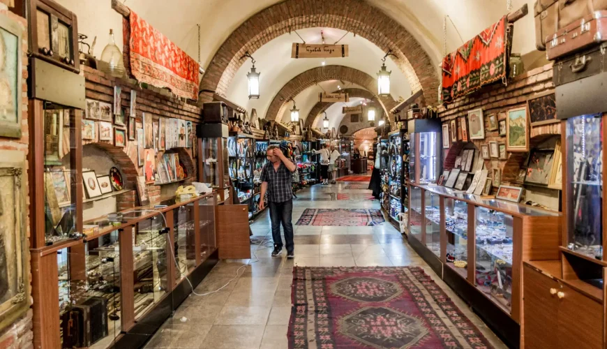 A long, arched hallway of an underground bazaar in Tbilisi, with display cases full of jewelry, art, and traditional goods